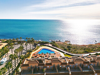 Aerial view Cabo Roig coastal town on southern Costa Blanca, Mediterranean Sea and seafront residential buildings during sunny day. Province of Alicante. Spain