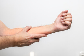 Hand pain, close-up of male hands on a white background
