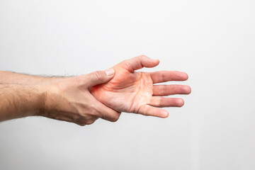 Hand pain, close-up of male hands on a white background
