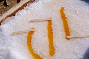 Maple syrup hardening on fresh snow to create maple taffy