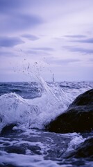 sedition. Ocean waves crashing against dark rocks with splashing water droplets in dramatic seascape. travel magazines, destination branding, designed for outdoor magazines and nature guides.
