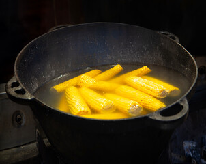 Yellow corn is cooked in a large cauldron