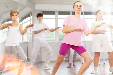 Fototapeta premium Group of teenagers learn to dance hip-hop and other modern dances in a spacious dance studio