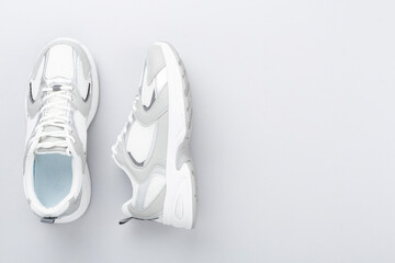 Pair of sneakers on color background, top view