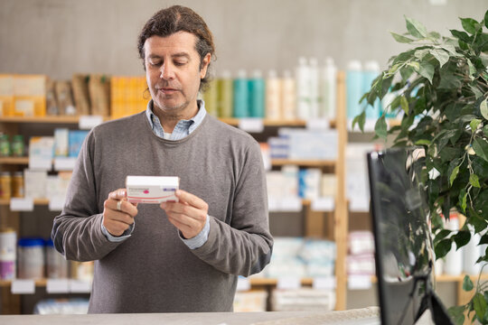 Male buyer buys paracetamol medicine at a pharmacy