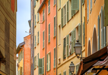 Obraz premium Picturesque crooked narrow street with colorful traditional houses in the medieval Old Town or Vieille Ville, French Riviera in Nice, France