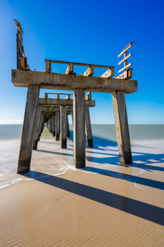 Long exposure photo pier on the beach shore