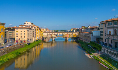 Obraz premium Aerial view of the iconic Ponte Vecchio bridge crossing the Arno River in Florence, showcasing historic architecture and dense city rooftops in Tuscany, Italy