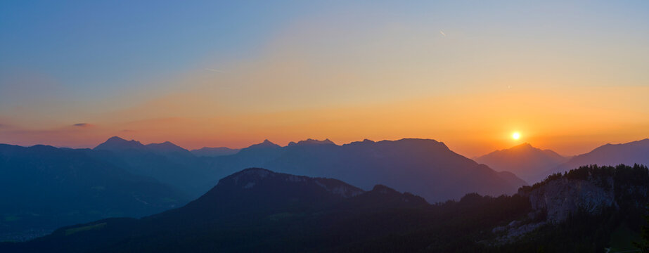 Breathtaking sunset over the Alpine mountains with the sun above Mount Schafberg in the Salzkammergut region, Austria. 