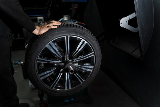 Technicians swap winter tires for summer ones using specialized equipment.