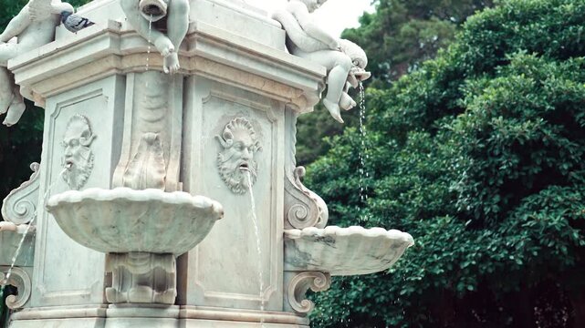 Historic stone fountain with sculpted faces in Santa Cruz de Tenerife park