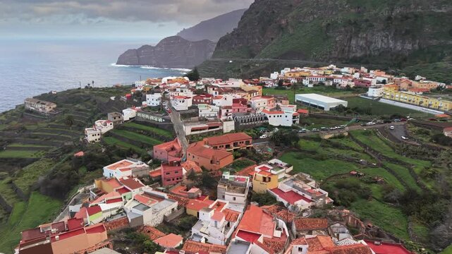 The bon-bon of La Gomera - Agulo village. White houses and terraced fields. Aerial view, Canary Islands, Spain. Traditional village of Agulo nestled among green terraced fields at La Gomera island
