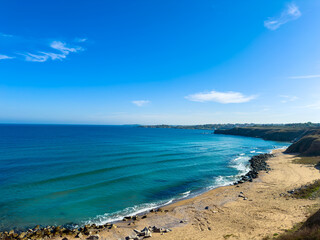 View of the ocean and sandy beach in a coastal region during daytime