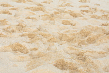 Textura de arena de playa con múltiples huellas de pies bajo luz natural. © Rubén Abdón
