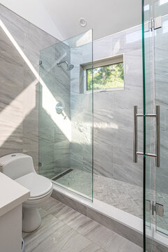 Modern bathroom with glass walk in shower and gray marble tile