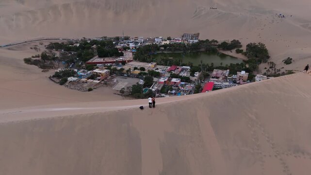 Aerial view of Huacachina, Peru's desert oasis, highlighting sand dunes and a tranquil lake