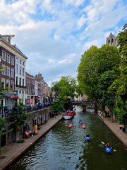 Fototapeta premium Colorful Kayaks and Tour Boats Navigating the Historic Oudegracht Canal in Utrecht
