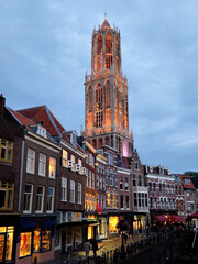 Naklejka premium Historic Dom Tower Rising Above Illuminated Utrecht Canal Streets at Dusk