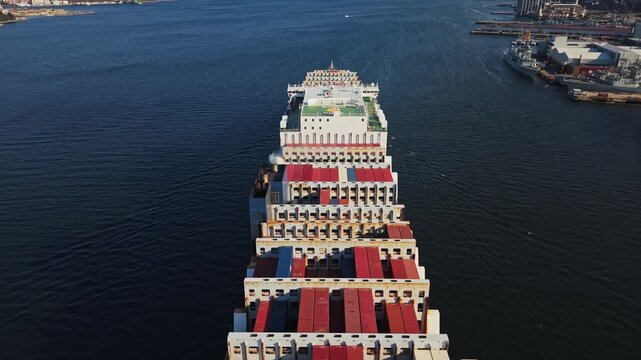 Large Cargo Ship Loaded With Multicolored Containers Traverses Canadian Waters. Aerial view Illustrates Modern Global Freight And Port-To-Port Logistics. Canada, Nova Scotia, Halifax. 