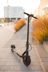 Electric scooter is parked on the street. An environmentally friendly form of transport.