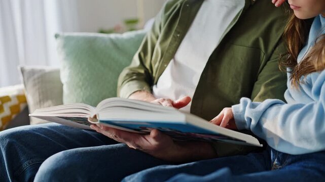 Smiling man reading daughter enjoying family leisure closeup. Home education