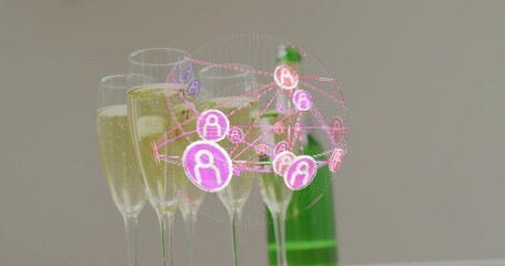 Displaying champagne flutes bubbling on white table with green bottle behind, magenta orb floating