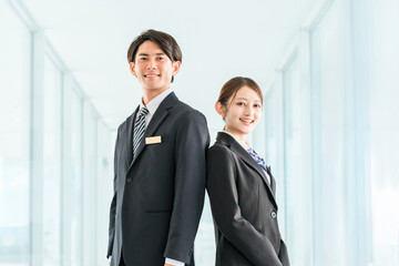 Fototapeta premium Young Asian male and female business people in suits (hotel workers, hoteliers, concierges, bankers)