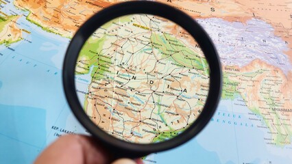 view of India, officially the Republic of India, is a country in South Asia on a geographical map of ASIA, seen using a magnifying glass