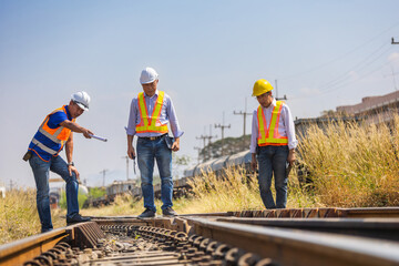 Railway engineers inspecting track condition during safety assessment, Transportation workers checking rail infrastructure at site, Rail maintenance team reviewing track integrity and safety standards