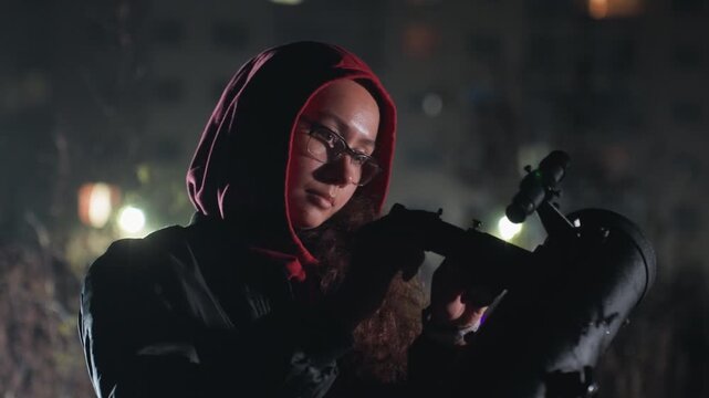 woman inspects telescope eyepiece under city lights, amateur astronomer preparing astrophotography setup, glowing display illuminating face, patient focus, handheld light for alignment, cold night,