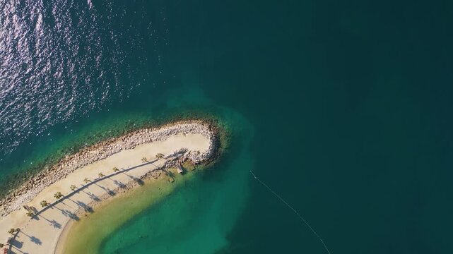 Tropical luxury resort sand beach with palm trees and blue sea water aerial top down view.
