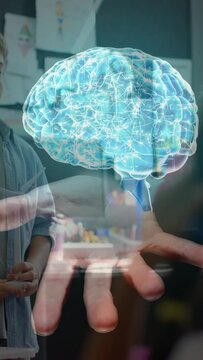Vertical video: Student raising hand starting hologram above palm teacher showing brain for school