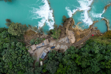 Water flows at Cascada El Salto in Huasteca Potosina with lush vegetation surrounding the area © juanjomenta