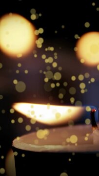 Vertical video: Closeup zooming tealight flame flickering wick glowing dust drifting for warm bokeh