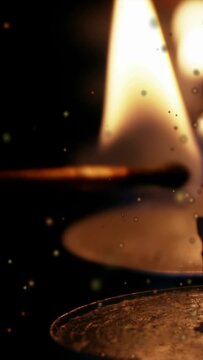 Vertical video: Offscreen push causing match sliding toward flame, tip darkening, glowing, igniting