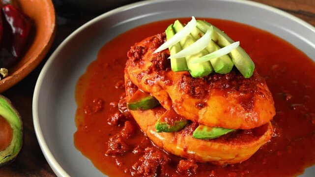 Traditional Mexican food known as chancla poblana with red adobo, chorizo ​​and avocado slices