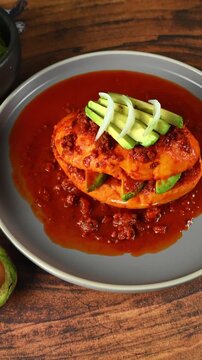 Mexican food known as chancla poblana with red adobo, chorizo ​​and avocado slices, top view