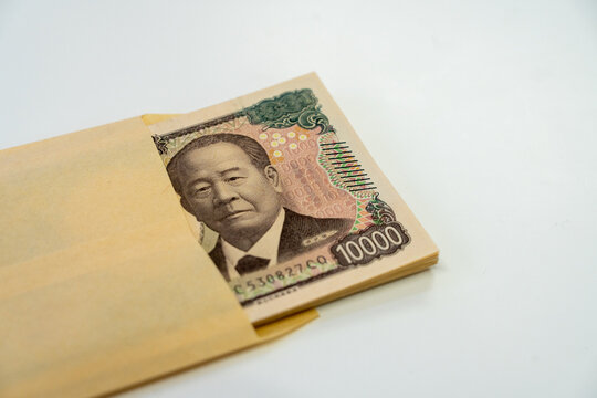 A stack of 10,000 yen bills in a brown envelope