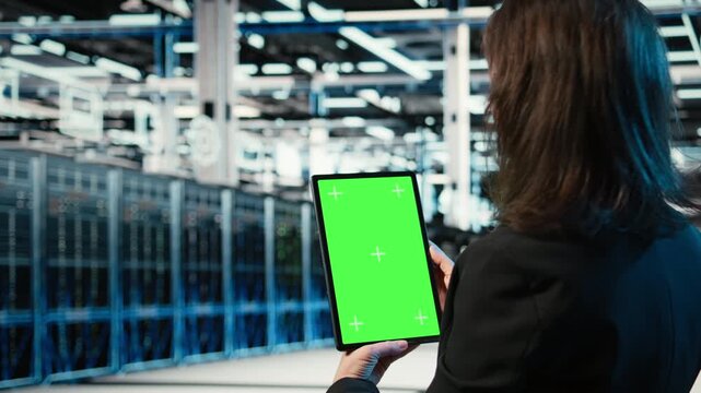Green screen tablet used by data center admin to optimize server load balancing. Server farm IT specialist using mockup device to adjust system parameters and improve efficiency, camera A