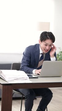 経営の戦略や結果のグラフを見る社長や経営者の悩む困る、忙しい慌てるスーツを着た男性のイメージの縦動画	
