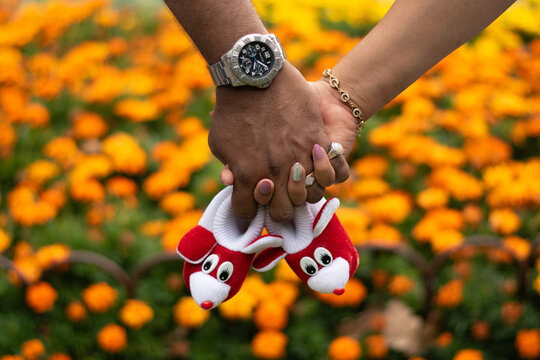 couple holding hands with their baby boots