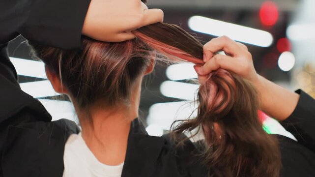 teen student undoing pink ponytail in studio closeup of hands unraveling dyed tips, hair released into loose waves, soft bokeh lights, festive background, motion and shine, playful transformation