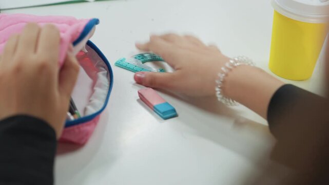 Clutterfree study space setup. Neatly arranged school materials on uncluttered working surface. Peaceful study environment featuring precise placement of stationery and decorative bracelet detail