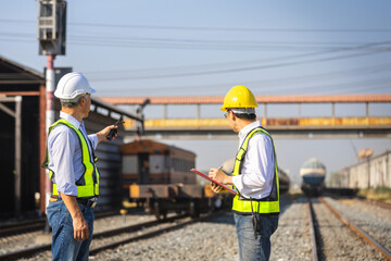 Railway supervisors coordinating train movements during yard inspection, Transportation engineers communicating operations, Rail industry professionals managing logistics and safety at train depot