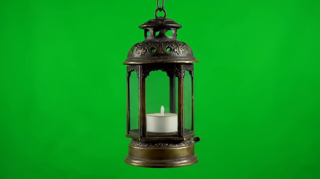 Old metal lantern with a lit candle inside, isolated against a vibrant green screen background, perfect for visual effects and design projects