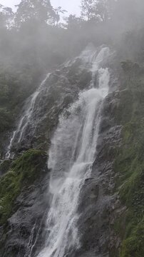4K 60FPS close-up video footage of Sikarim Waterfall captured with a 3x zoom, highlighting the powerful flow of water cascading over dark rocky cliffs