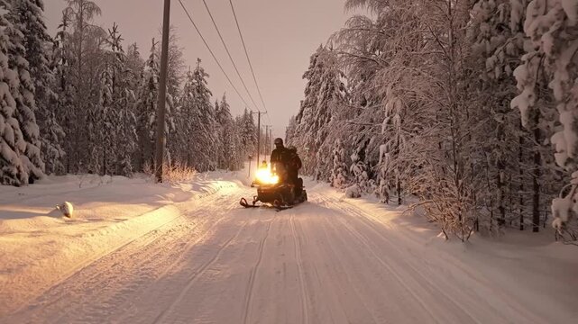 Tourists snowmobiling through Lapland winter wilderness, snow covered landscapes and Arctic beauty, Tracking shot