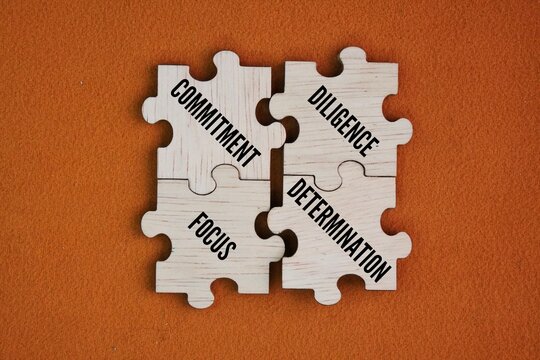 Wooden puzzle with the words commitment, diligence and focus, determination. essential, interconnected traits for achieving success and personal growth, acting as the foundation for overcoming obstacl