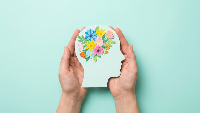 Mental Wellness Concept Hands Hold Papercut Head Silhouette Adorned with Colorful Paper Flowers