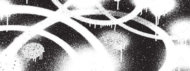 Abstract white graffiti spray paint drips on black background.